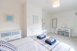 een witte slaapkamer met een bed met 2 kussens erop bij Little Hotsie in Southwold