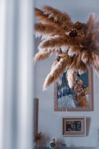 a mirror on a wall with a dried plant at Maison Garnier Hôtel de Charme Biarritz in Biarritz