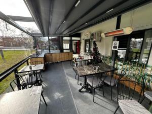 un restaurante vacío con mesas, sillas y ventanas en Bademi Room en Edirne