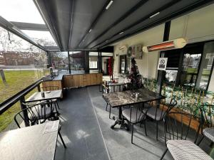 an empty restaurant with tables and chairs and windows at Bademi Room in Edirne