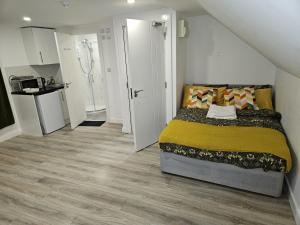 een kleine slaapkamer met een bed en een keuken bij Impeccable 5-Bed House in Orpington in Orpington