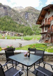 einen Tisch und Stühle auf einer Terrasse mit Bergblick in der Unterkunft Maison Chez Les Roset in Baulen