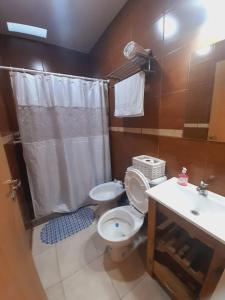 a bathroom with a toilet and a sink and a shower at Casa entre Montañas in San Juan