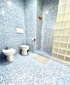 y baño de azulejos azules con aseo y ducha. en Barrio San Miguel Más que apartamentos, en Murcia