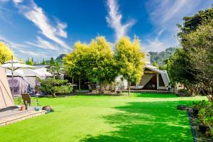 un patio con césped verde y una casa en Liu Mu Sen, en Miaoli