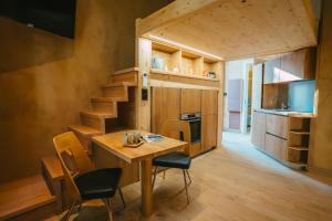 eine Küche und ein Esszimmer mit einem Holztisch und Stühlen in der Unterkunft Domaine Bohème I art de vivre in Guebwiller