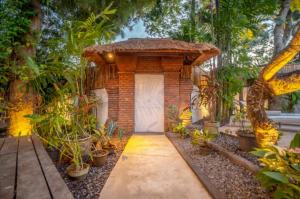 a brick house with a white door and some plants at Villa Jado 2 - 3 Bedroom Villa With Private Pool in Kerobokan