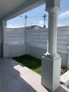 a porch with a white fence and a pillar at Victorian Haven in Observatory in Cape Town