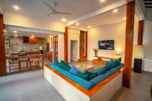 a living room with a blue couch and a kitchen at Villa Jado 2 - 3 Bedroom Villa With Private Pool in Kerobokan