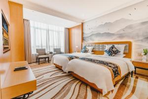 a hotel room with two beds and a desk at Wenzhou Hangbin International Hotel in Wenzhou