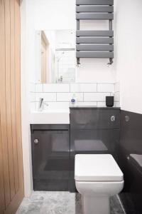 a bathroom with a white toilet and a sink at 8 Bed, comfortably sleeps 10, 3 Bath house, 5 Mins Manchester Centre in Manchester