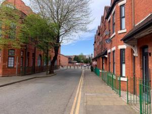 an empty street in an alley between brick buildings at 8 Bed, comfortably sleeps 10, 3 Bath house, 5 Mins Manchester Centre in Manchester