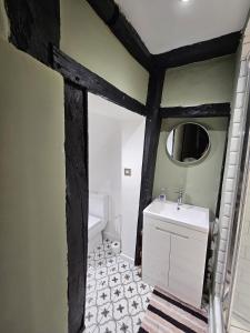 a bathroom with a white sink and a mirror at Startop Farmhouse in Marsworth