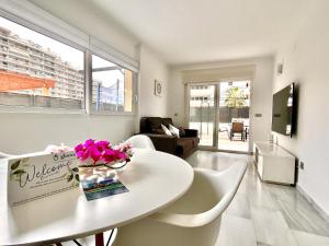 a living room with a white table and flowers on it at Alkadir Home in Villajoyosa