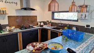 a kitchen with a counter with bowls of fruit on it at Bali Villa Pokhara in Pokhara