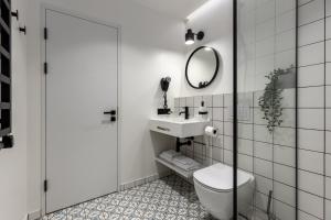 a bathroom with a toilet and a sink and a mirror at Konventa Sēta Hotel - Keystone Collection in Riga