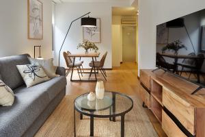 een woonkamer met een bank en een tafel bij Eiffel - The Rentals Collection in San Sebastian