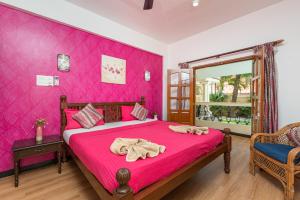 a pink bedroom with a large bed with pink sheets at Villa Calangute Phase 1 in Calangute