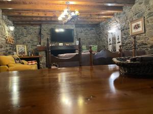 卡尼略的住宿－PASSAMANÉ PB - Canillo - Casco Antiguo，客厅配有大木桌和电视