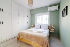 - une chambre avec un lit avec des placards blancs et une fenêtre dans l'établissement Stunning apartment in the heart of Athens, à Athènes