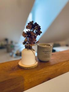 a vase and a cup on a wooden shelf at Destino in Sulzbach-Rosenberg
