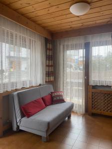 um sofá sentado numa sala de estar com janelas em Ciasa Cianins em San Vigilio Di Marebbe