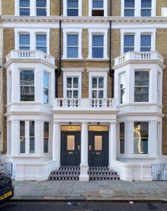 un gran edificio blanco con una puerta negra en Earls Court East Serviced Apartments by StayPrime en Londres