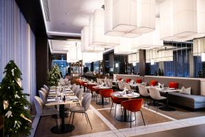 a restaurant with tables and chairs and christmas trees at Hilton Garden Inn Vilnius City Centre in Vilnius