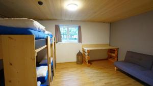 a small room with bunk beds and a desk at Naturfreunde Hostel Grindelwald in Grindelwald