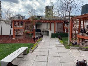 una casa con un banco en un jardín en Ñuñoa, Bello departamento, La mejor ubicacion, en Santiago