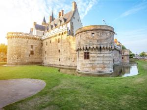 a large castle with a grass yard in front of it at Ibis Nantes la Beaujoire Parc Expo in Nantes