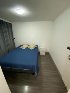 Un dormitorio con una cama azul en una habitación. en Ñuñoa, Bello departamento, La mejor ubicacion, en Santiago