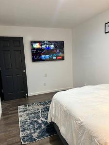 a bedroom with a bed and a tv on the wall at Cozy 2BED 6min EWR NYC DTWN in Newark