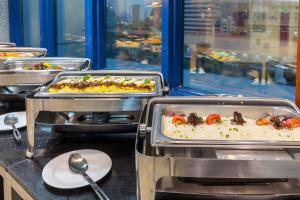 a buffet line with several trays of food at Barakat Burhan Hotel فندق بركة برهان in Mecca