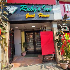 a restaurant with a red sign on the front of it at Ruby's Inn in Kolkata