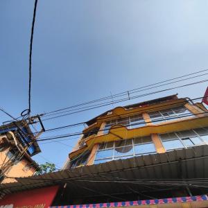 a tall yellow building with lots of windows at Ruby's Inn in Kolkata