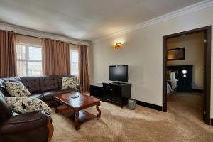 uma sala de estar com um sofá e uma televisão em Majestic Five Hotel em Palapye