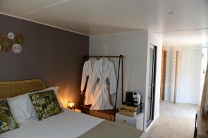 1 dormitorio con cama y albornoz colgado en la pared en Camping Casa Di Caccia, en Marina di Bibbona