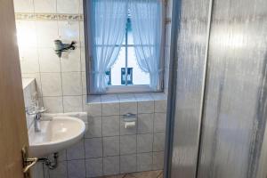 a bathroom with a sink and a shower with a window at Gästehaus Quirin in Garmisch-Partenkirchen +69 photos