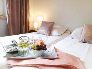 a tray with a plate of fruit on a bed at M&E Cztery pory roku Szklarka 25A in Bystrzyca Kłodzka