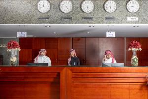 فندق بركة برهان في مكة المكرمة: مجموعة من الناس تقف خلف كونتر بالساعات