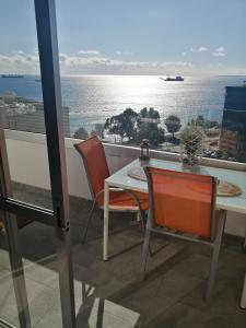 a balcony with a table and chairs and a view of the ocean at Amazing Sea Place in Limassol