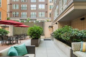 eine Außenterrasse mit Tischen, Stühlen und Sonnenschirmen in der Unterkunft Bellevue jr 1br w lounge gym nr coffee shops SEA-612 in Bellevue