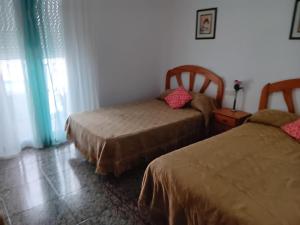 a bedroom with two beds and a window at La Replaceta in Chulilla