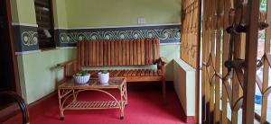 Zimmer mit einer Bank und einem Tisch mit Topfpflanzen in der Unterkunft The Mountain Tree home in Wayanad
