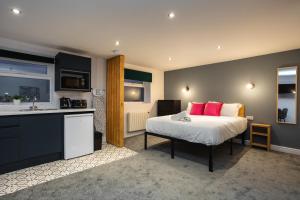 een slaapkamer met een bed met roze kussens en een keuken bij 59a Thorne Road Apartments in Doncaster