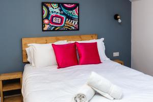 a bedroom with a white bed with red pillows at 59a Thorne Road Apartments in Doncaster