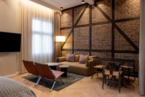 1 dormitorio con pared de ladrillo, sofá y mesa en Ascot Hotel, en Copenhague