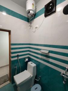 a bathroom with a toilet with blue and white stripes at Sadafuli Guest House Assagao in Assagao