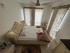 een kleine slaapkamer met een bed en een raam bij Hibiscus Apartments in Dhaka